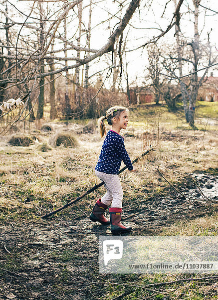 Mädchen  das im Vorfrühling in einem Garten spielt  Schweden.
