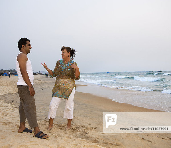 Man and woman talking on the beach  India.