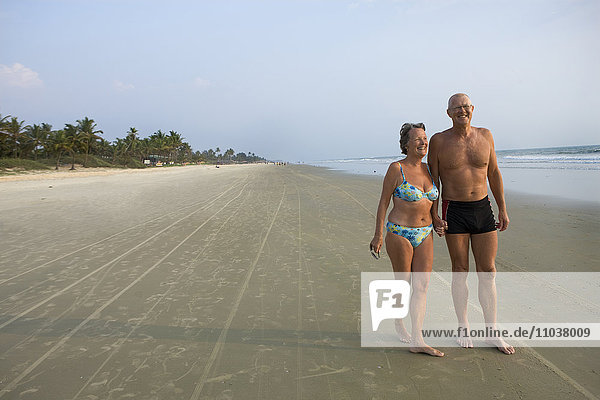 Ein älteres Ehepaar  das am Strand spazieren geht  Thailand.