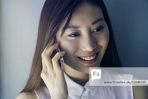 Woman smiling while using cell phone