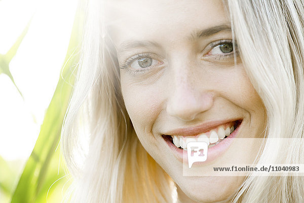 Young woman smiling cheerfully outdoors  portrait