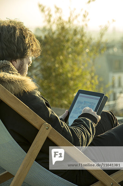 Mann mit digitalem Tablett im Freien