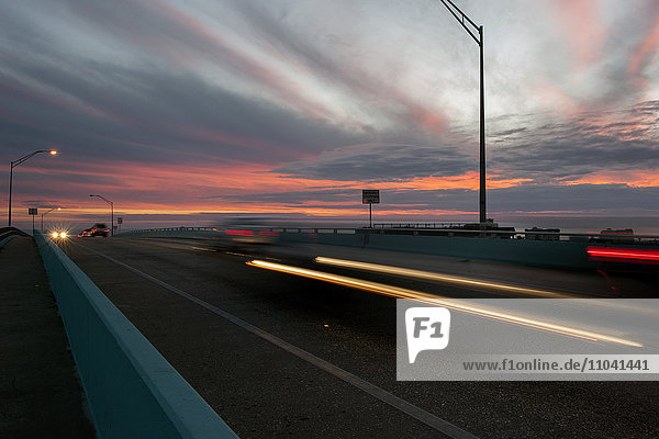 Lichtspuren vom Verkehr auf der Autobahn bei Sonnenuntergang