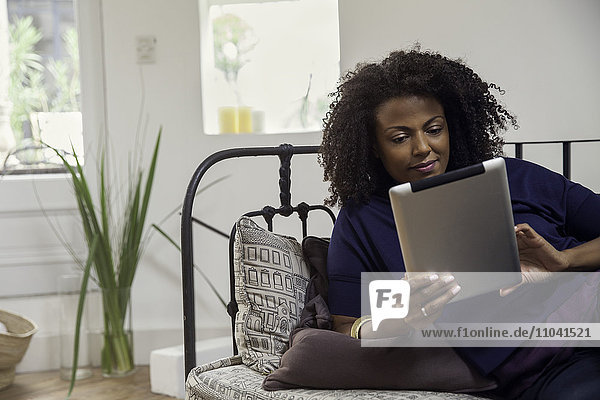 Frau überprüft E-Mail mit digitalem Tablett