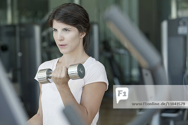 Frau beim Heben von Gewichten im Fitnessstudio