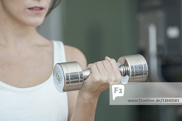 Woman lifting dumbbell  cropped