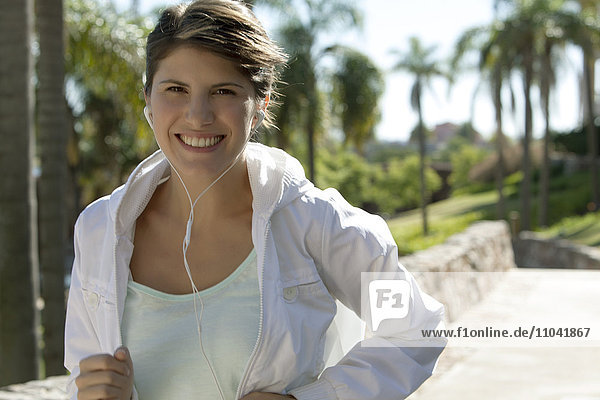 Woman jogging  smiling cheerfully  portrait