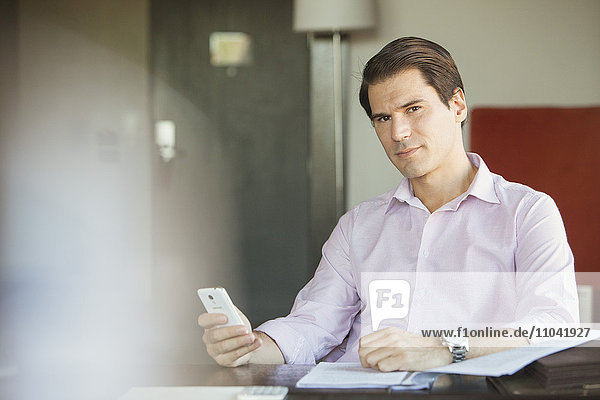 Businessman using smartphone at desk  portrait