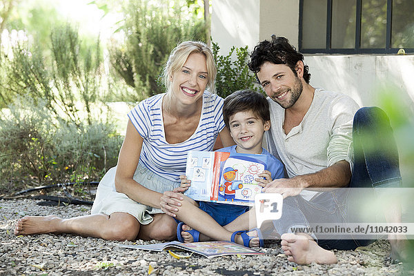 Eltern zusammen mit dem Kind lesen lernen  Portrait