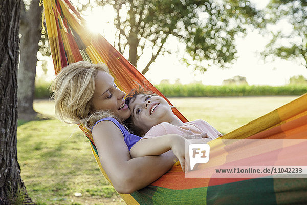 Mother and son relaxing in hammock together