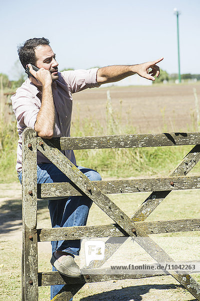 Farmer telefonieren  um Probleme auf dem Bauernhof zu melden.