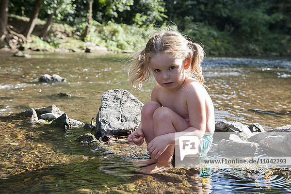 Little girl playing in shallow stream