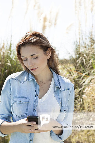 Junge Frau mit Smartphone im Freien