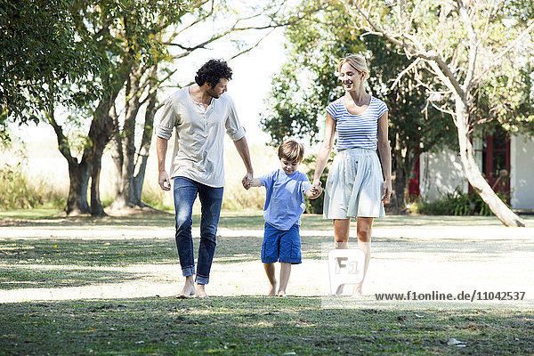 Familie mit einem Kind beim gemeinsamen Spaziergang im Freien