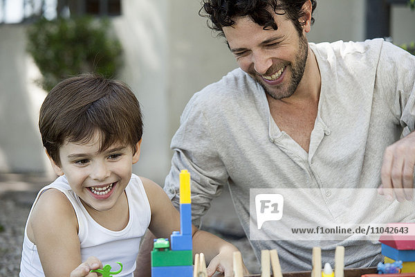 Vater und Sohn lachen beim Spielen mit Spielzeug