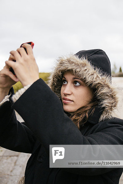 Caucasian woman taking selfie outdoors