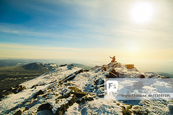 Frau sitzend auf Berg im Winter