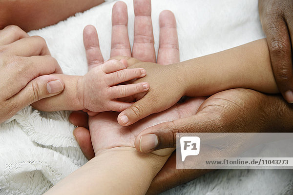Intertwined hands of Mixed Race family