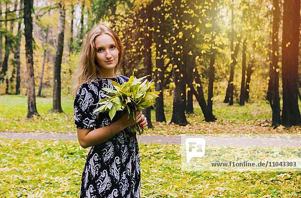 Kaukasische Frau mit Blumenstrauß im Park