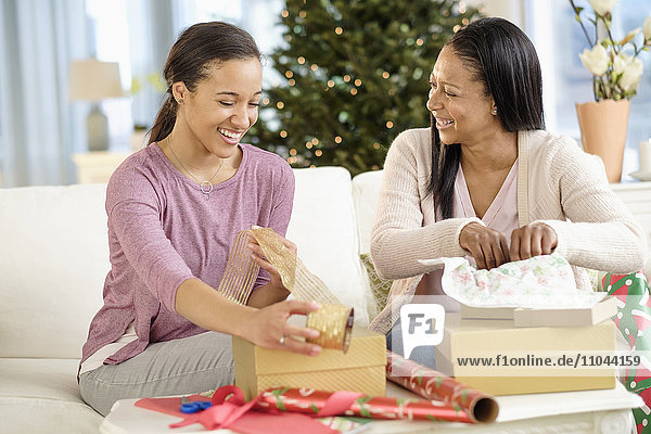 Mother and daughter wrapping Christmas gifts