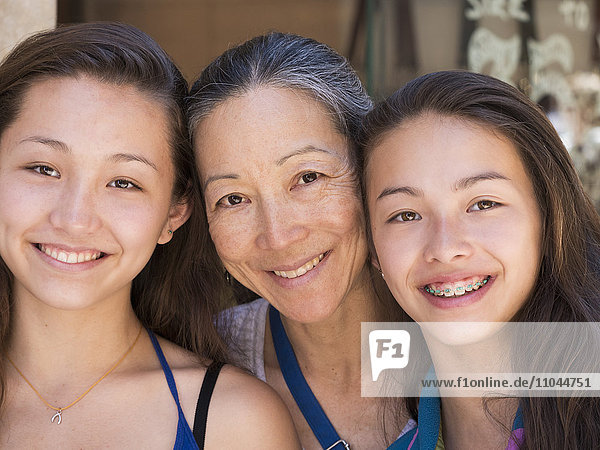 Close up of smiling Asian mother and daughters