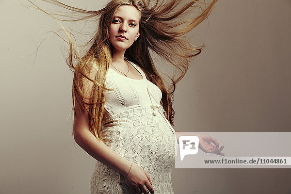 Schwangere Frau mit wehendem Haar