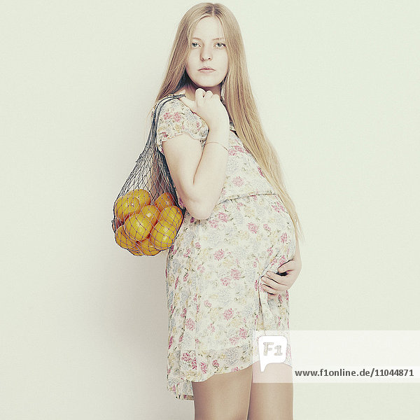 Schwangere Frau trägt Tasche mit Obst