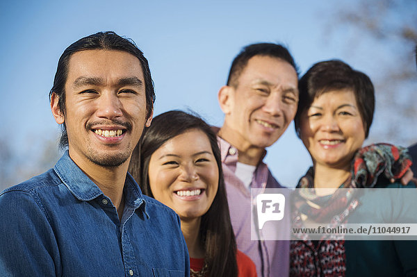 Chinesische Familie lächelt im Freien