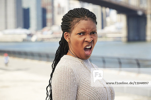 Schwarze Frau mit angewiderter Haltung im Hafengebiet
