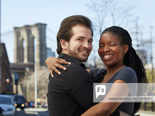 Lächelndes Paar  das sich in der Stadt umarmt
