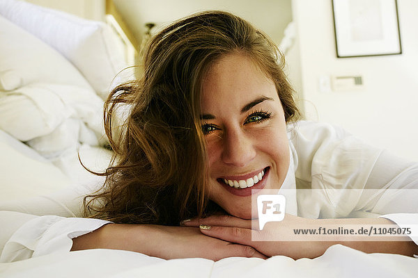 Gemischtrassige Frau lächelnd auf dem Bett