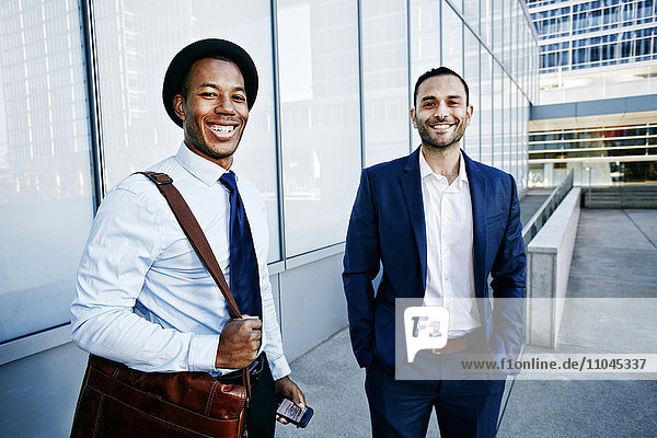 Geschäftsleute lächelnd vor Bürogebäude