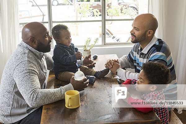 Väter und Kinder sitzen am Tisch