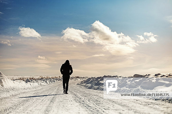 Caucasian man walking in snowy landscape