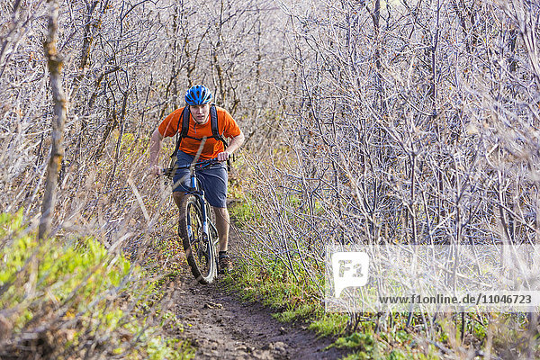 Kaukasischer Mann fährt Mountainbike im Wald