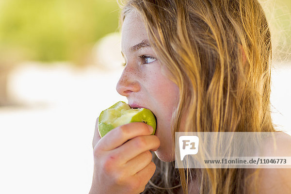 Kaukasisches Mädchen isst grünen Apfel