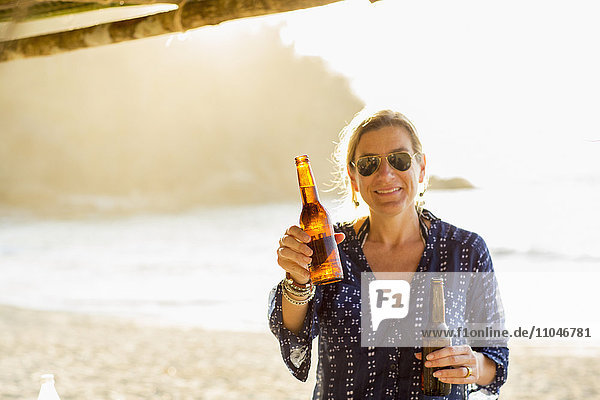 Kaukasische Frau mit zwei Bierflaschen in der Hand