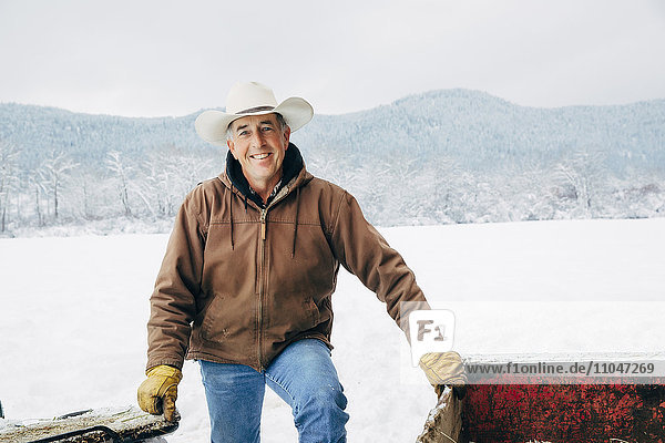 Caucasian farmer smiling in snowy field