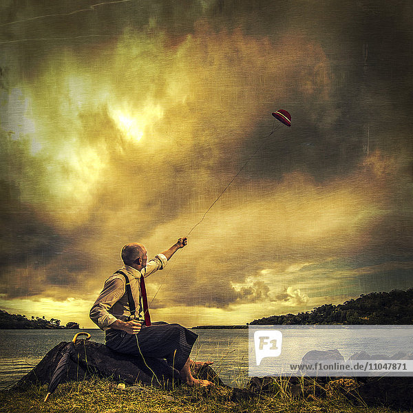 Caucasian man flying derby kite near remote lake