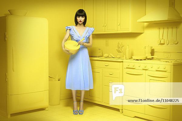 Kaukasische Frau in gelber  altmodischer Küche mit Rührschüssel