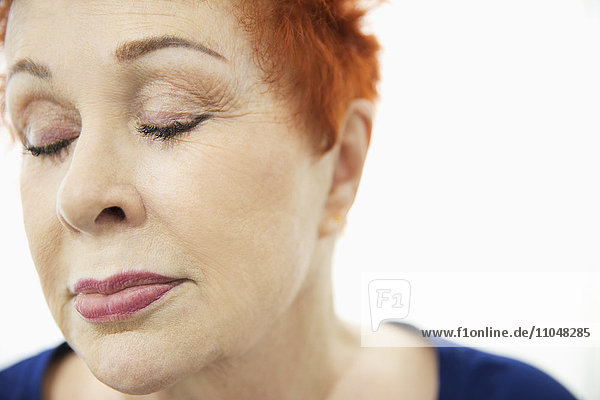 Face of older Caucasian woman with eyes closed