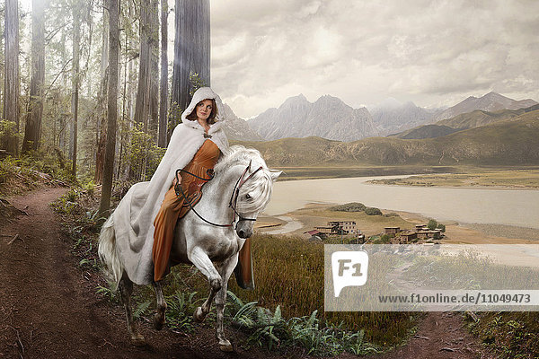 Kaukasische Frau reitet Pferd in abgelegenem Wald