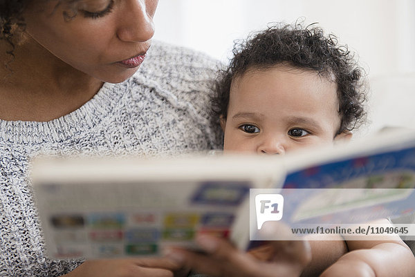 Mutter liest ihrem kleinen Sohn ein Buch vor