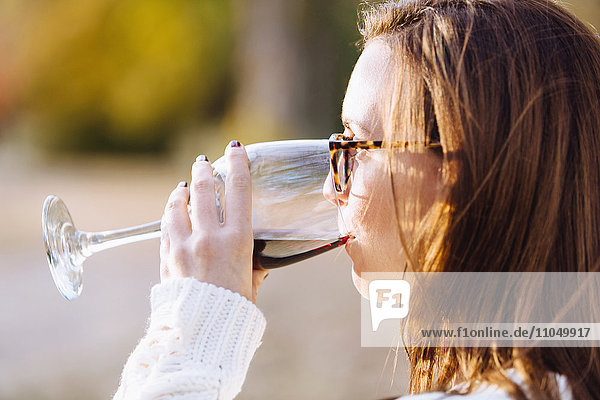 Caucasian woman drinking wine outdoors