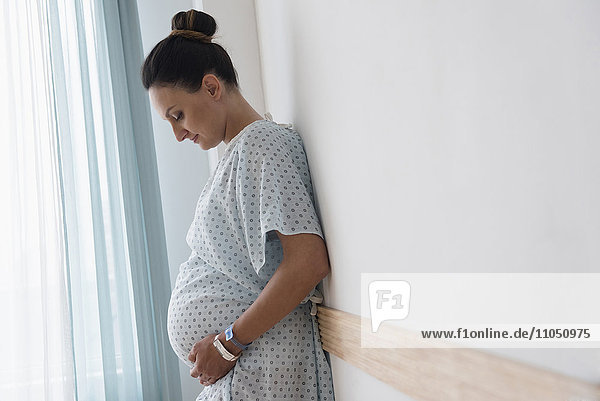 Pregnant Caucasian woman wearing hospital gown