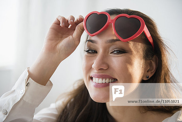 Smiling woman wearing heart shaped sunglasses