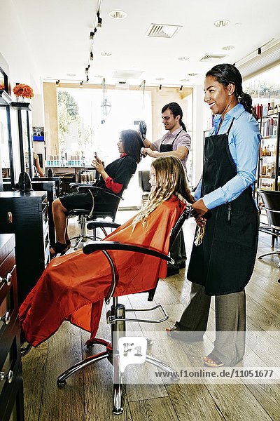 Friseure und Kunden im Friseursalon