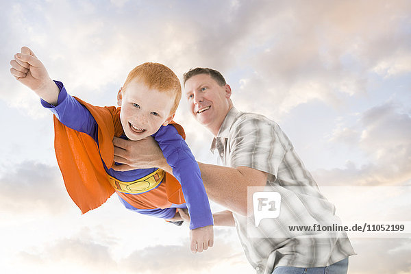 Caucasian father and son playing superhero