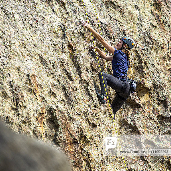 Caucasian woman climbing rock