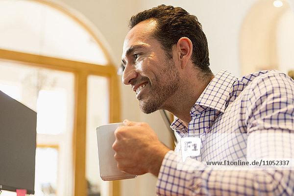 Hispanischer Geschäftsmann trinkt Kaffee im Büro